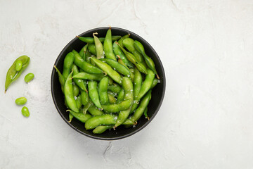 Wall Mural - Raw edamame soya beans with salt and sauce on light gray background.