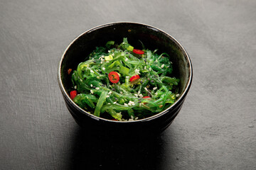 Wall Mural - Wakame seaweed with sesame and chilli on gray background. Asian food concept.