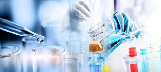 Wall Mural - hand of scientist holding flask with lab glassware in chemical laboratory background, science labora