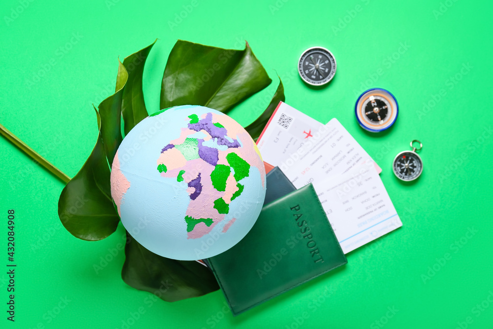 Globe with passports, tickets and compasses on color background