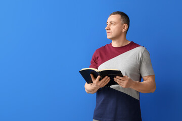 Wall Mural - Man with Bible on color background