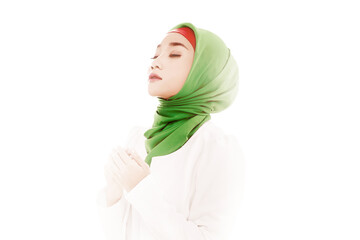 Wall Mural - Asian Muslim woman in a veil sitting while raised hands and praying