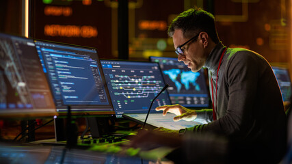 Aufkleber - Professional IT Technical Support Specialist Making an Intercom Announcement on a Microphone and Working on Desktop Computer in Monitoring Control Room with Big Digital Screens with Server Data.