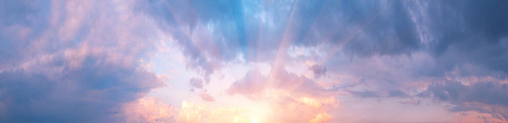 Wall Mural - panorama of cloudy sky with pink clouds and sun