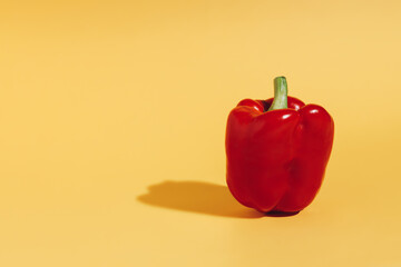 Wall Mural - Fresh red bell pepper isolated on vibrant yellow background. Creative organic vegetable concept. Banner for healthy food or diet with copy space. Pop art aesthetic.