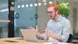 Loss, Young Redhead Man reacting to Failure on Laptop in Office 