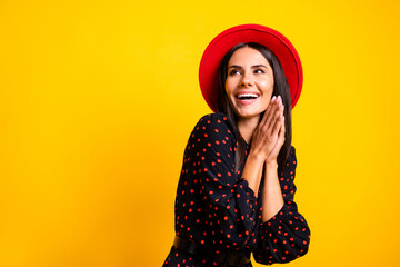 Sticker - Photo of shiny impressed lady dressed clothes cap looking empty space arms together cheek isolated yellow color background