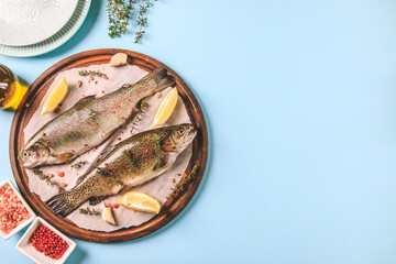 Wall Mural - two raw rainbow trouts on paper with thyme and lemon. Fish trout. Top view. Free space for your text.