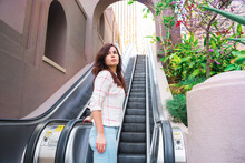 A Young Girl Stands On An Escalator In The Courtyard Of Business Buildings In Downtown Los Angeles