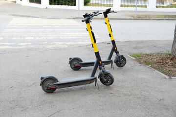 Two parked scooters in the city. Modern youth mode of transport