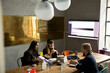© Maskot - Businesswoman with female colleagues discussing over color swatch in conference room