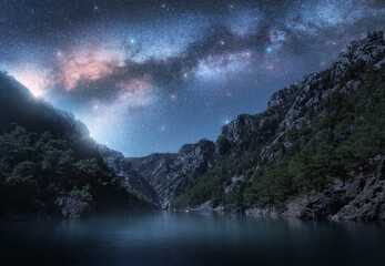 Wall Mural - milky way and stars over beautiful mountain canyon and blue sea at night in summer. colorful landsca