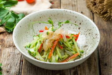 Poster - salad with jellyfish and vegetables on old wooden table