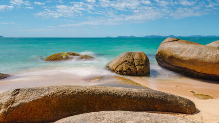 daytime long exposure photography of sea waves on stones