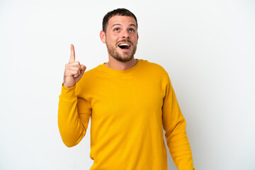 Young Brazilian man isolated on white background pointing up and surprised