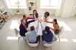 © Studio Romantic - Diverse team of happy enthusiastic people join hands. Multiethnic teammates, business partners and friends motivating each other in group meeting around office table. Teamwork, participation concept