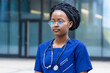© Елена Якимова - smart black girl medical student in glasses, serious young african american woman doctor in blue uniform, stethoscope, concentrated afro female nurse at university, college, hospital, clinic