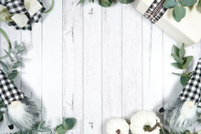 Decorated Border Background. On-trend Farmhouse Aesthetic Flatlay Flatlay With Farmhouse Style Decor, Stack Of Books, And Bows On A White Wood Background. Negative Copy Space.