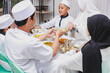 © Gatot - Happy family muslim during eid mubarak celebration by eating together at home
