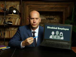 Wall Mural - Man wearing blue business suit and showing laptop with written text Disabled Employee .