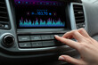 © Pixel-Shot - Woman tuning into a radio station in car