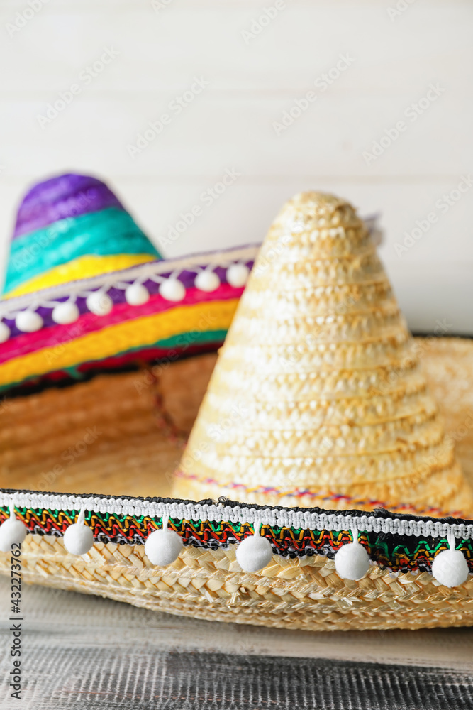 Mexican sombreros on wooden background, closeup