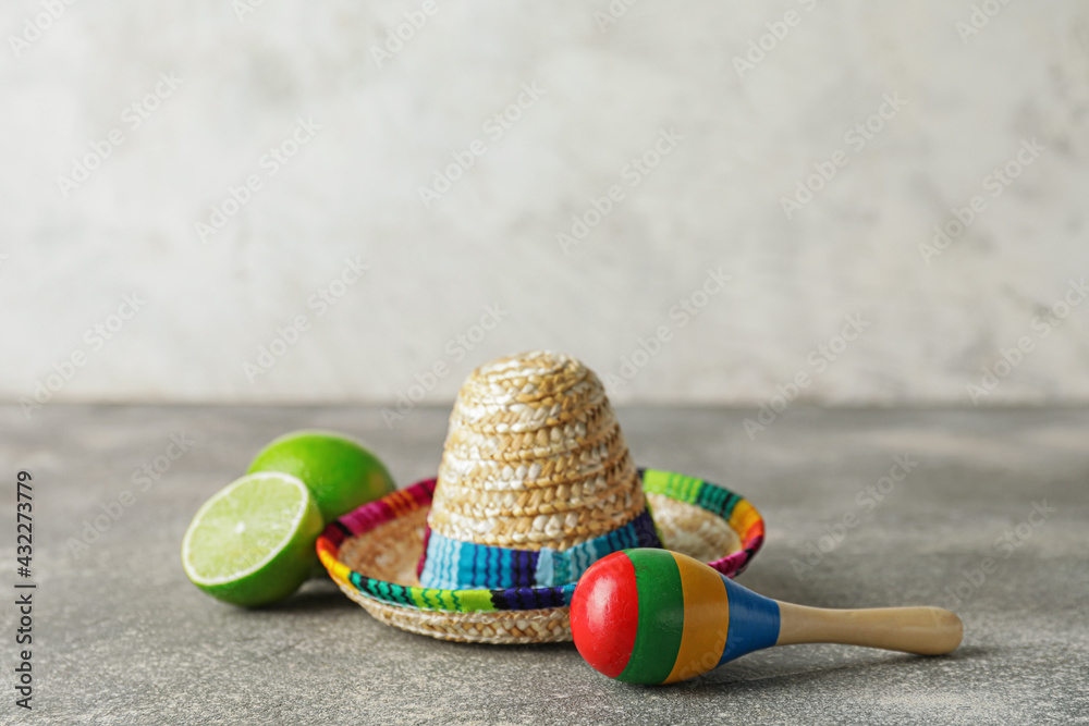 Mexican sombrero, maracas and lime on grunge background
