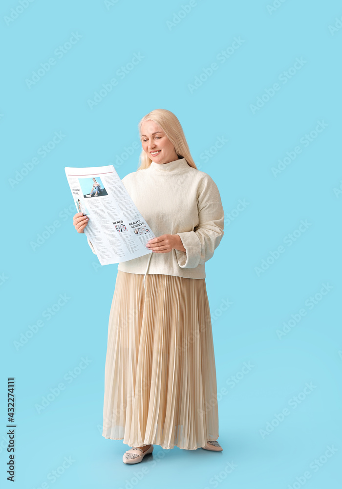 Mature woman with newspaper on color background