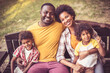 © liderina - Portrait of happy African American family outdoors.