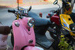  A vintage  pink    motorcycle, moped  stands in a parking against the backdrop of  street , side  view