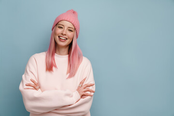 Wall Mural - Young white woman with pink hair smiling and posing at camera