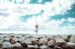 © Davide Angelini - Senior woman doing yoga exercise tree pose at beach - Calm and meditation concept
