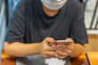 © Quang - Female wearing medical face mask and using smartphone