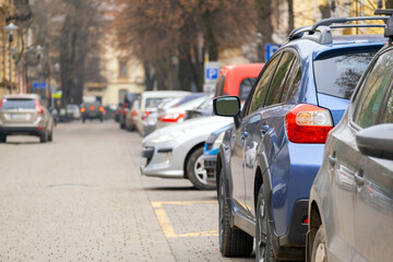 Canvas Print - Cars parked in a row on a city street side.