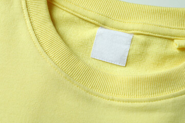 Wall Mural - Yellow sweatshirt with blank label, close up