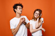 © SHOTPRIME STUDIO - young couple in white t-shirts fun emotions orange background