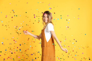 Poster - Happy woman and falling confetti on yellow background