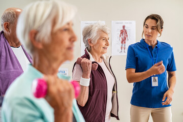 Trainer helping senior people exercise