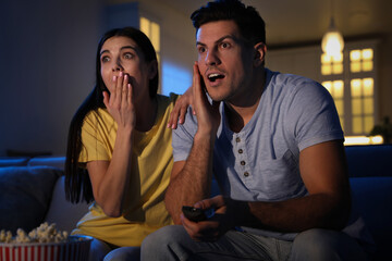 Wall Mural - Couple watching movie with popcorn on sofa at night