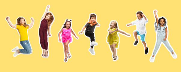 Wall Mural - Group of elementary school kids or pupils jumping in colorful casual clothes on yellow background. Collage.