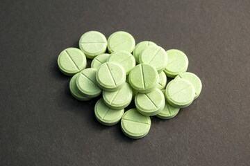 green pills on black background