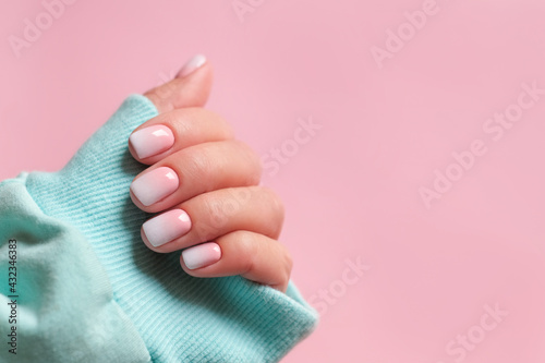 Gradient manicure and Hands Spa. Beautiful Woman hand closeup. Manicured nails and Soft hands skin. Beautiful woman\'s nails with beautiful baby boomer manicure, pink background. Copy space