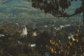 Wall Mural - Sun rays and misty at the valley with white church in Bao Loc city, Lam Dong province, Vietnam