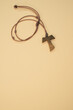 Top view of a wooden tau cross necklace isolated on a brown background