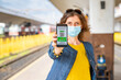 © Melinda Nagy - health Vaccine Passport for Coronavirus or Covid-19. Traveller Using Mobile Phone with Vaccination in Immune Status to Certificated International Traveling in train station