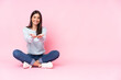 Young caucasian woman isolated on pink background holding copyspace imaginary on the palm to insert an ad