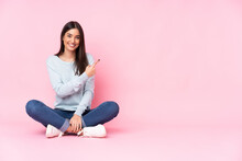 Young Caucasian Woman Isolated On Pink Background Pointing To The Side To Present A Product