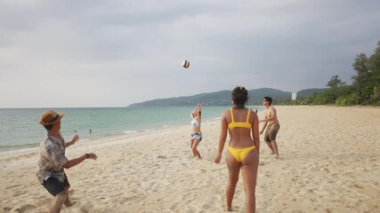 Wall Mural - 4K Group of Asian man and woman friends playing beach volleyball together on tropical beach in sunny day. Male and female friendship enjoy and having fun outdoor lifestyle activity on summer vacation