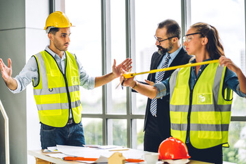 Wall Mural - Professional of team engineer cargo foreman in helmets working with blueprint and construction tool on table at the construction site