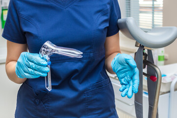 Gynecologist holding a gynecological speculum with gloves